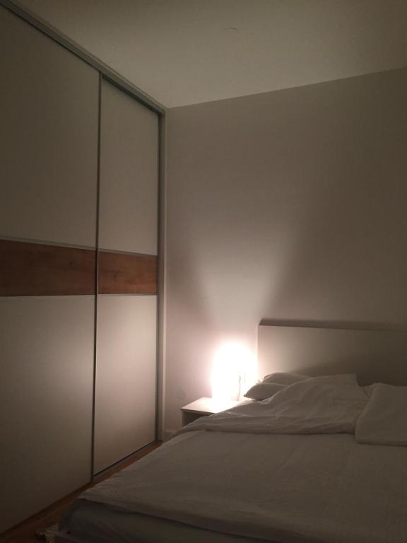 a bedroom with a white bed and a lamp at Velesajam in Zagreb