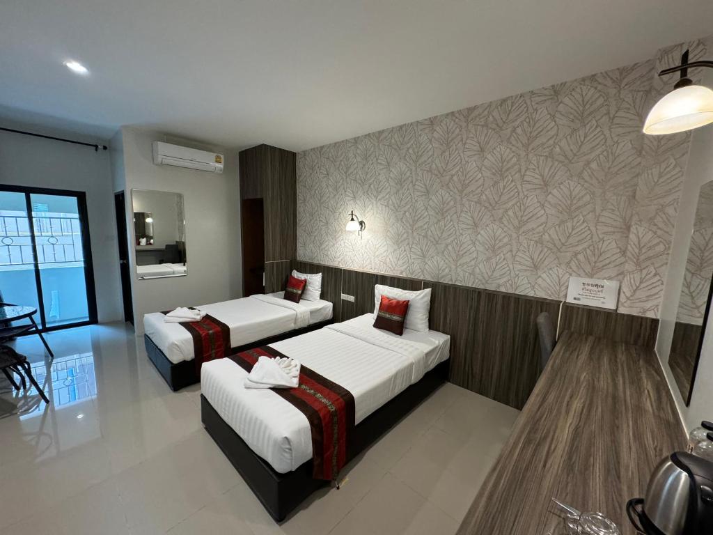 Habitación de hotel con 2 camas y pared en THE HUB SURATTHANl en Surat Thani