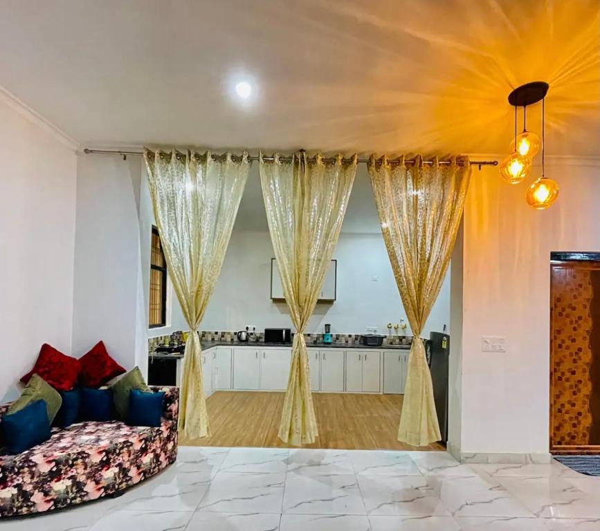 a living room with a couch and curtains at Centaurus Pvt. villa with lawn in Noida
