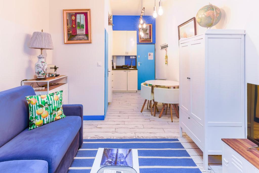 a living room with a blue couch and a kitchen at Studio Travel 24M2, 120m Vieux-Port ,Clim , Wifi ,Accès avec code, canapé lit in Marseille