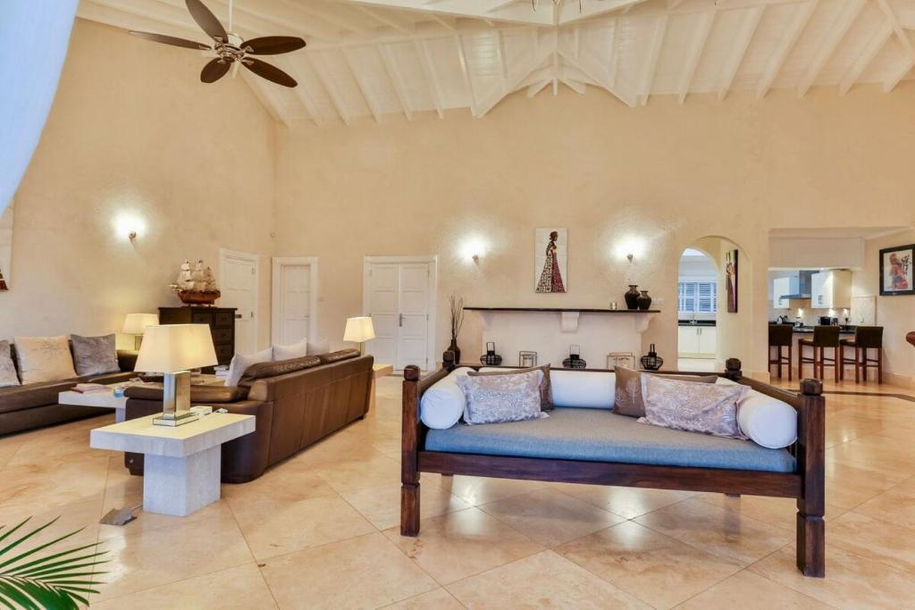 a living room with a couch and a table at Grandiose 4 BR Sea Facing Villa in Cap Estate