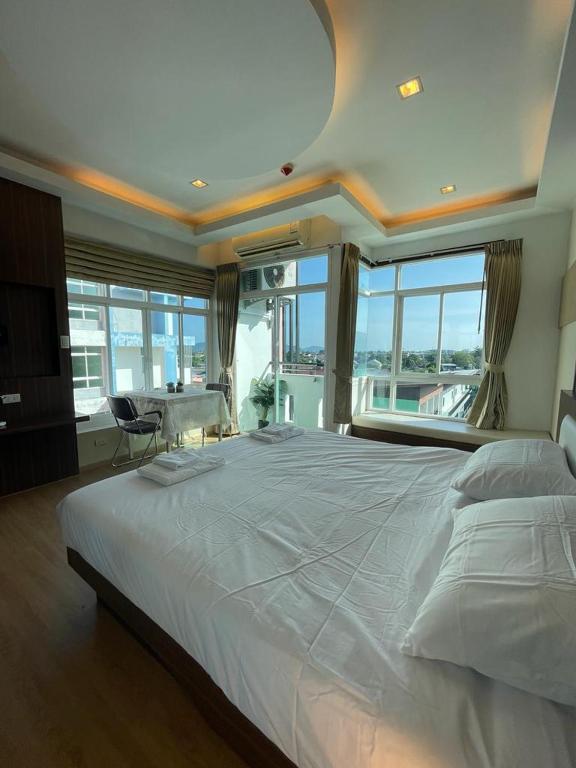 Studio 1 Chambre lumineux avec vue à 180° في Ban Klang: غرفة نوم كبيرة مع سرير أبيض كبير مع نافذة كبيرة