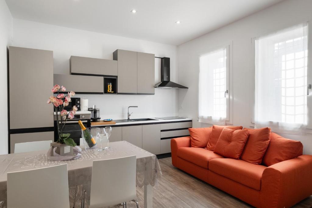 un salon avec un canapé orange et une table dans l'établissement Civico 36 a due passi dal Centro - Casa Guido, à Vicence