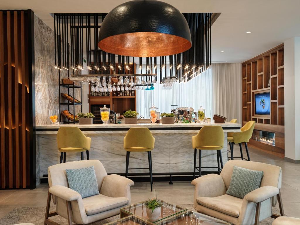 a bar at a hotel with chairs and a counter at The Chedi Luštica Bay in Tivat