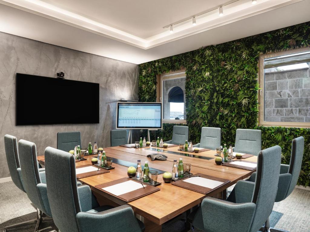 a conference room with a large wooden table and chairs at The Chedi Luštica Bay in Tivat