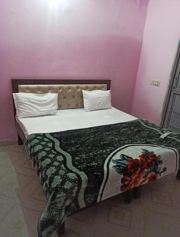 Una cama en una habitación rosa con colcha. en HOTEL BLUE ICE, en Chandīgarh