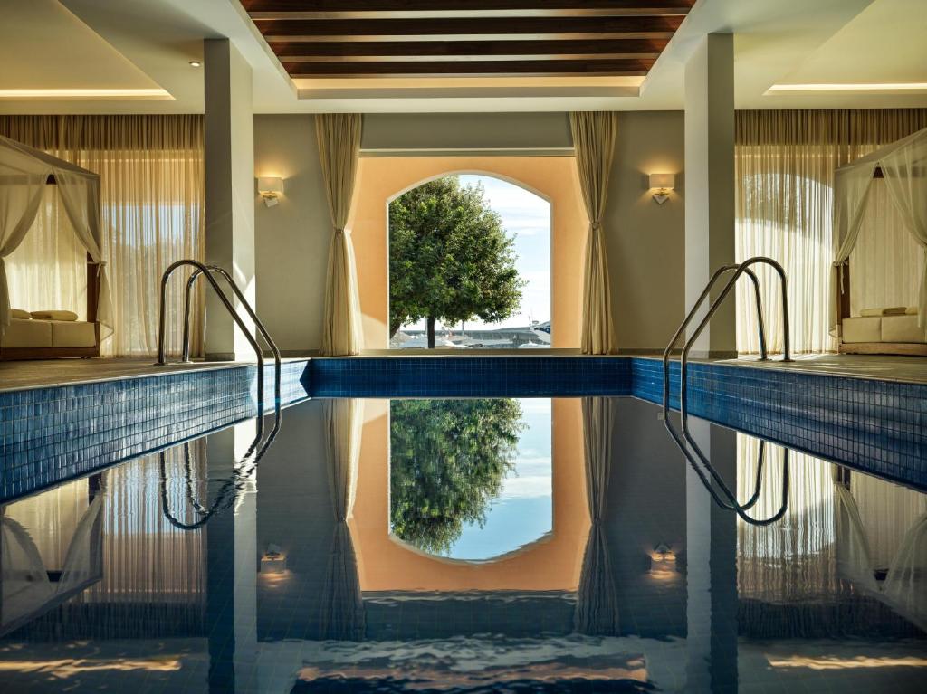 a swimming pool in a hotel room with a reflection in the water at The Chedi Luštica Bay in Tivat