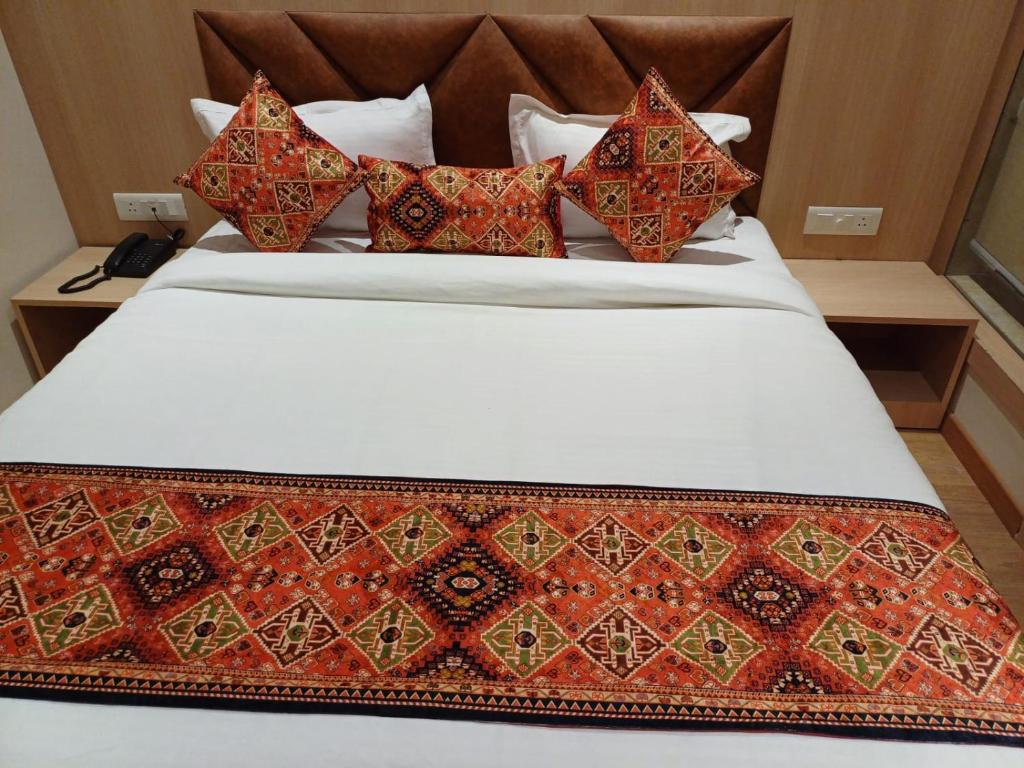Bett mit bunten Kissen auf einem Zimmer in der Unterkunft Hotel JR Grand 100 Meter From Golden Temple in Amritsar