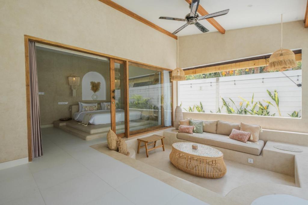 ein Wohnzimmer mit einem Bett und einem Sofa in der Unterkunft Gili Boho Villas - Aesthetic Private Pool Villas in Gili Trawangan