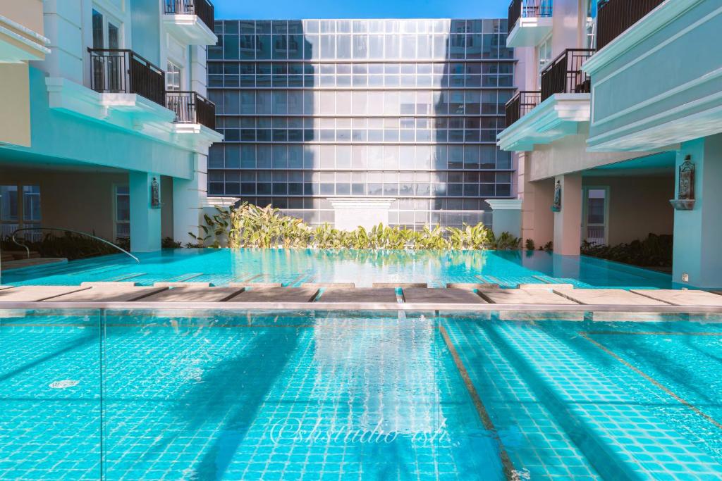 a swimming pool in front of a tall building at Saint Honore Studio Retreat with Amenities in Iloilo City