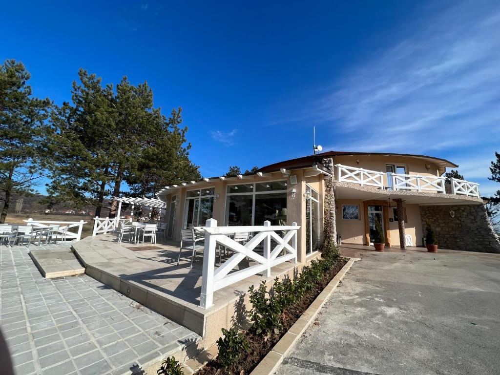 une maison avec une clôture blanche devant elle dans l'établissement Garni hotel Oblačinsko jezero, à Oblačina