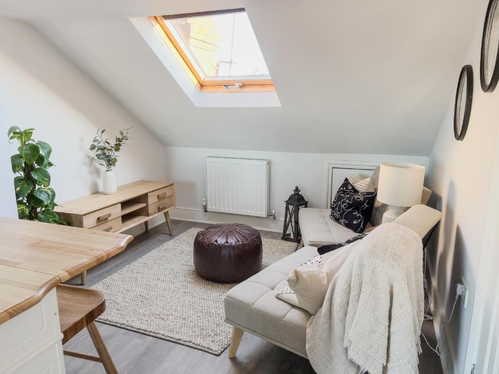 a living room with a couch and a skylight at Whimsical Land in London