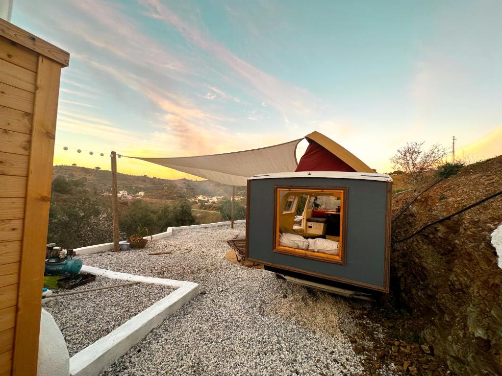 una piccola casa con uno specchio sul fianco di una collina di Romantic accommodation - Hottub & Sauna ad Almogía