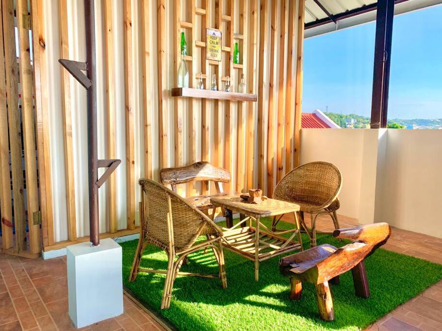 un patio con 2 sillas y una mesa sobre hierba en 4F Bohemian Apartment for 4 with Beach View en Bangcusay