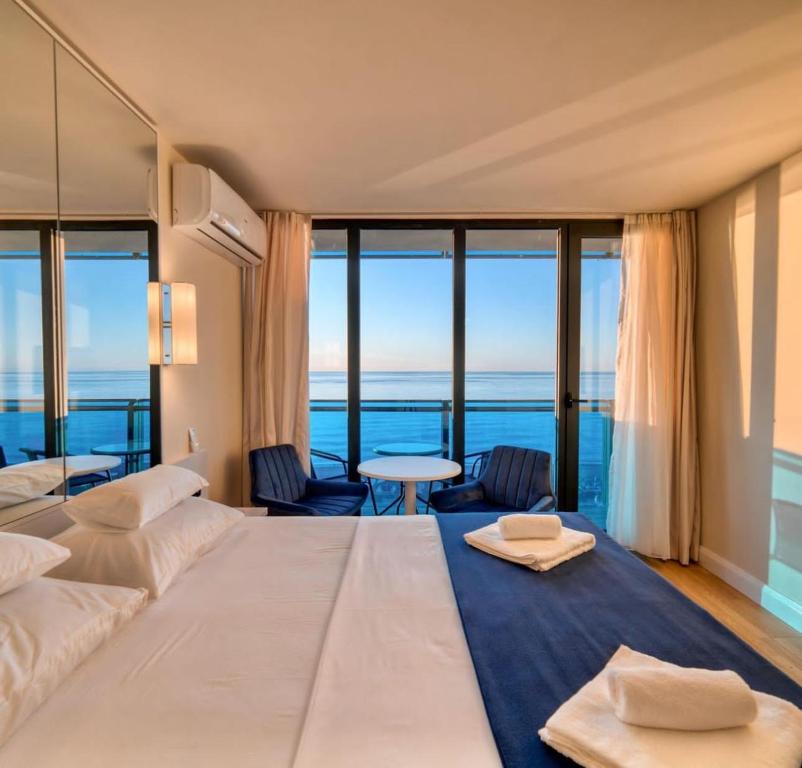a bedroom with a large bed with a view of the ocean at Queen apartments in batumi in Batumi