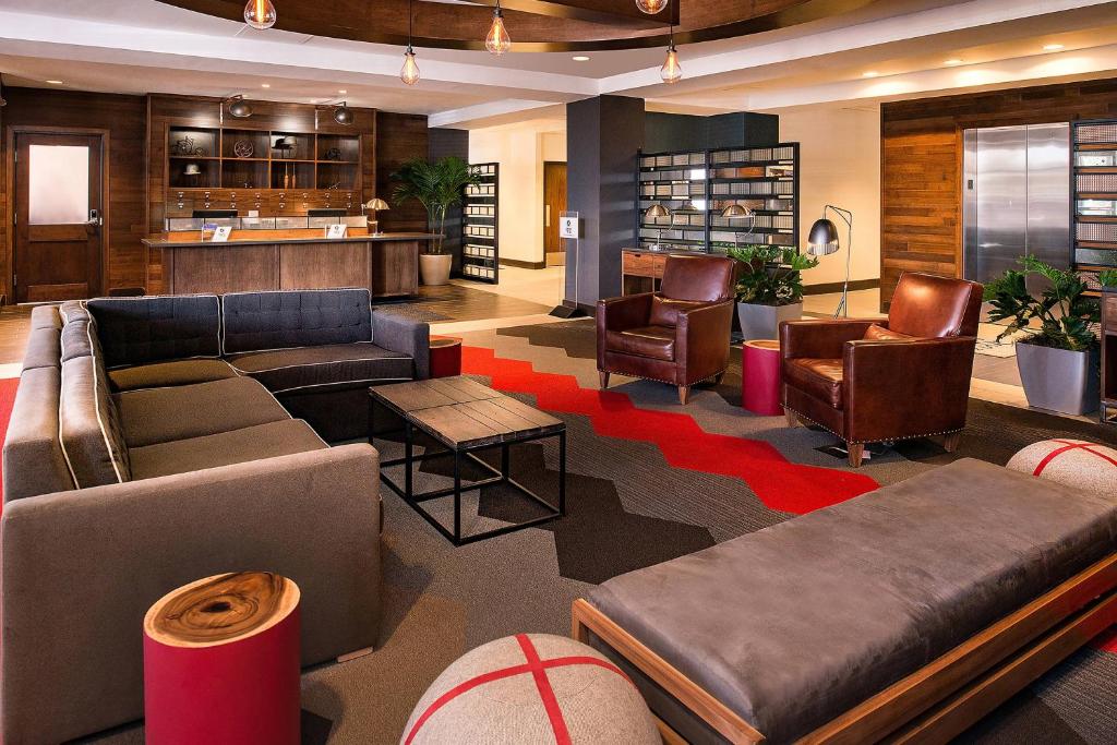 a lobby with couches and chairs and a bar at Four Points by Sheraton Detroit Metro Airport in Romulus