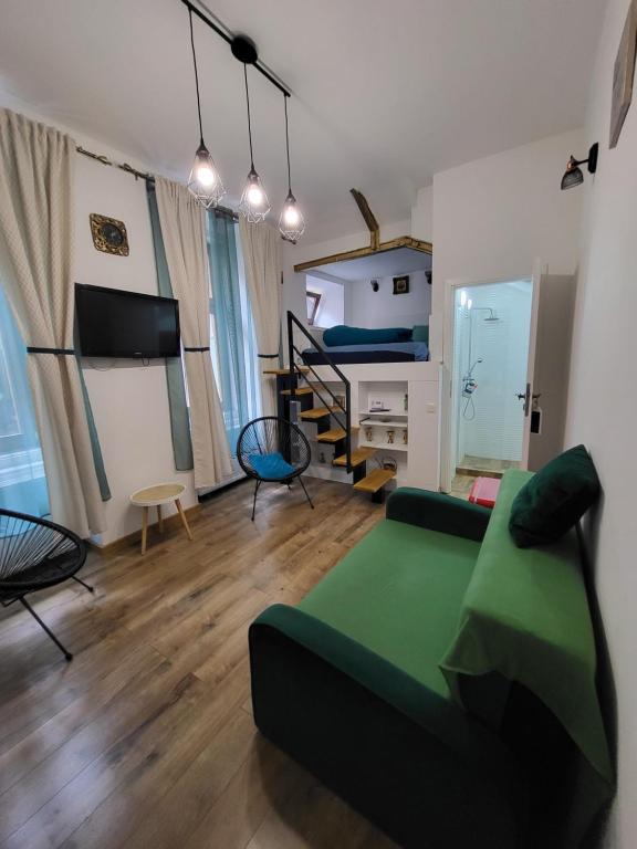 a living room with a green couch and a bed at Casa Silvia in Cluj-Napoca