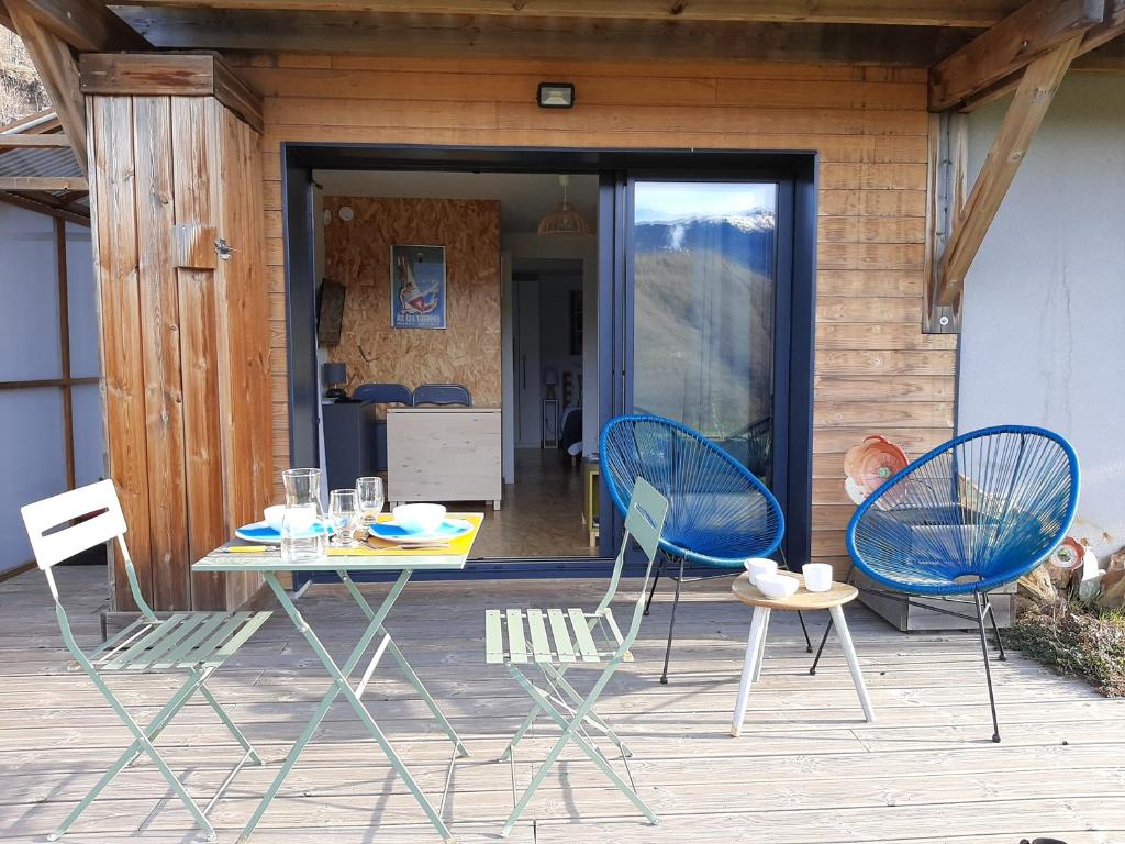 une table et des chaises assises sur une terrasse couverte avec une table et des chaises dans l'établissement CHALET la VEILLA, à Ax-les-Thermes
