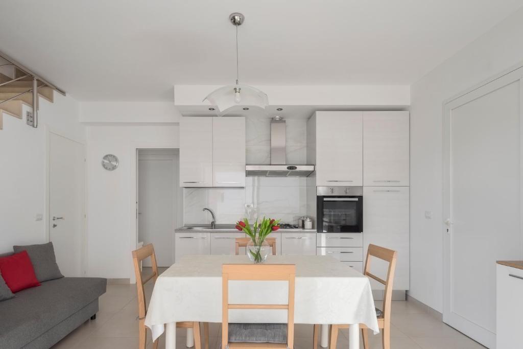 a kitchen and dining room with a table and chairs at DolceVitaSuites - Modern 3 Bdr Villa in S. Lorenzo in San Lorenzo