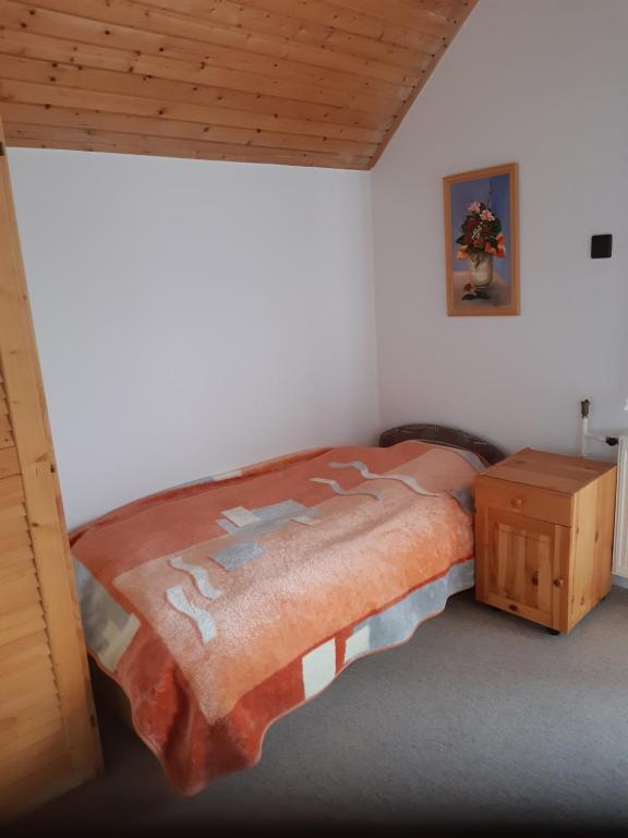 1 dormitorio con 1 cama grande y 1 mesa en Balatonberényi Vendégház, en Balatonberény