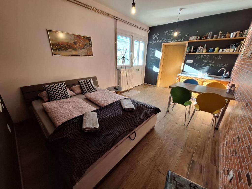 1 dormitorio con cama, escritorio y mesa en Apartment GREEN&URBAN, en Celje