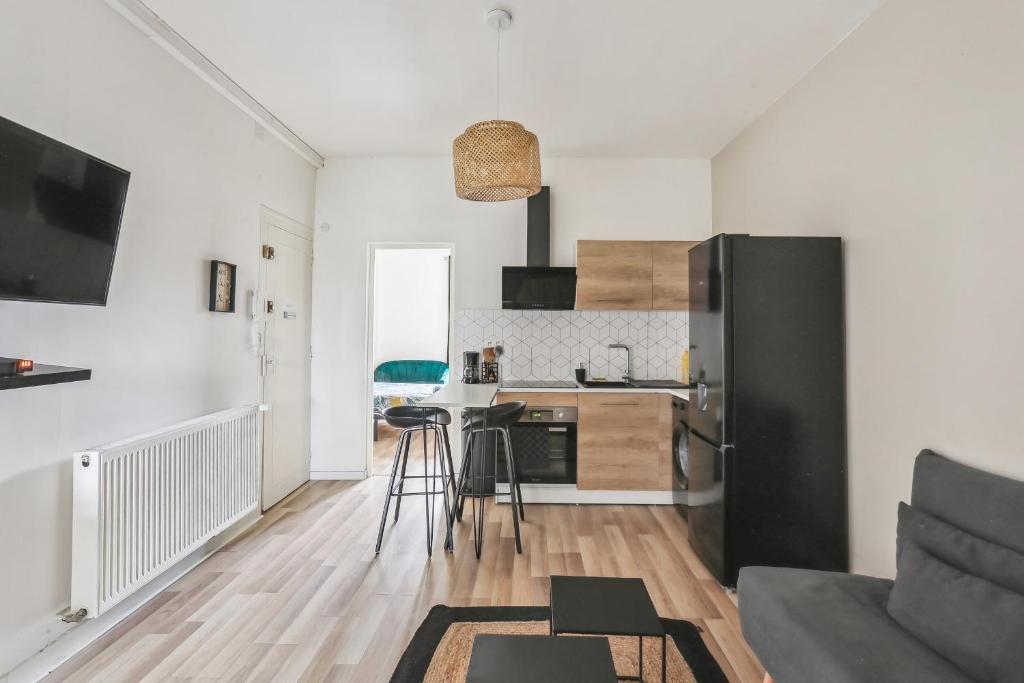 Il comprend une cuisine et un salon avec un réfrigérateur noir. dans l'établissement Charmant Appart Spacieux Rénové 4 Pers, au Mans