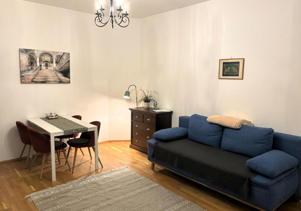 sala de estar con sofá azul y mesa en Casa Nostra - Ruhige Stadtwohnung mit Balkon, en Viena