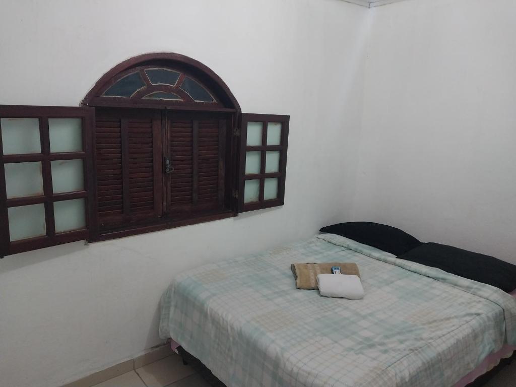een slaapkamer met een bed met een boek erop bij Guarus house plaza shopping in Campos dos Goytacazes