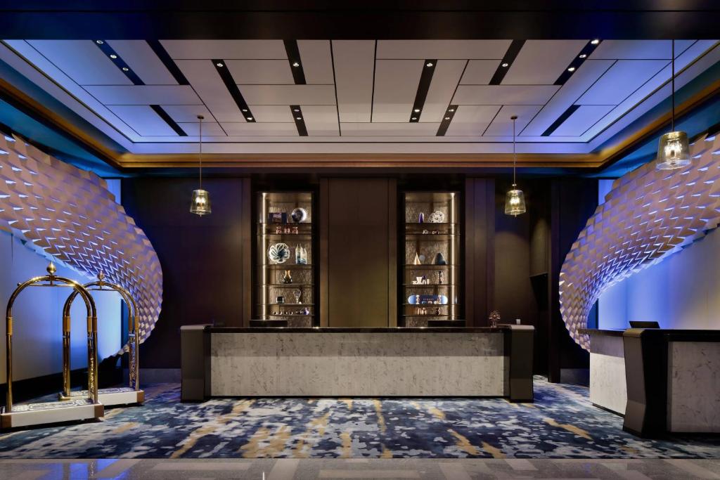 a lobby with a reception desk and two glass doors at mesm Tokyo, Autograph Collection in Tokyo