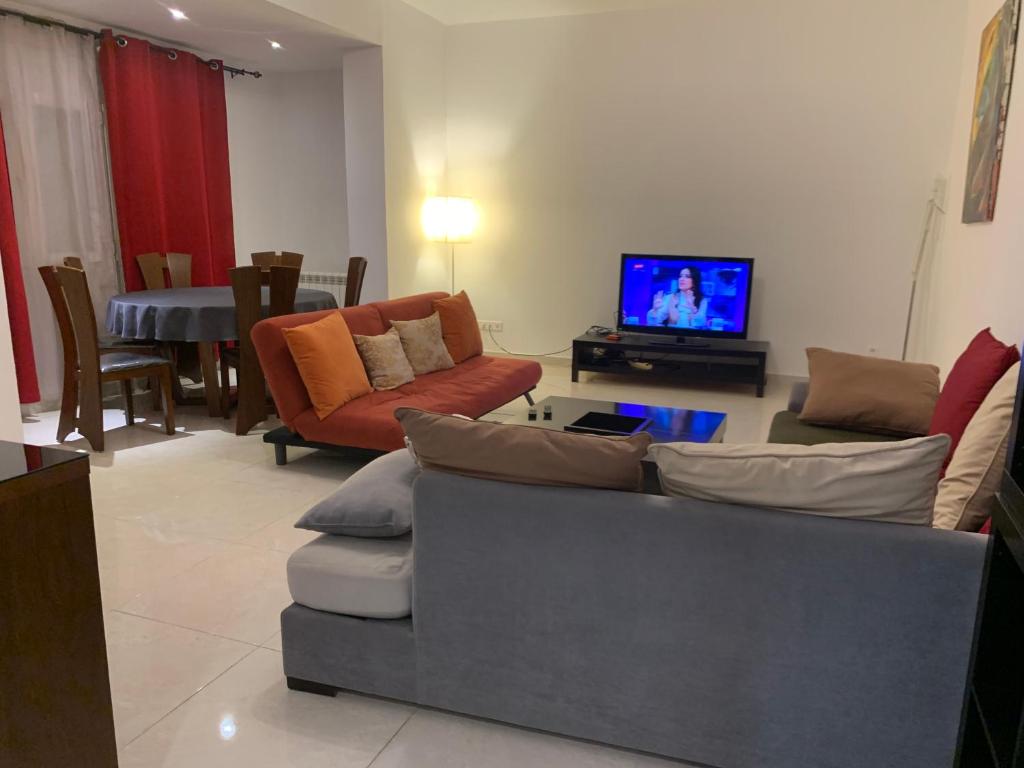 uma sala de estar com um sofá e uma televisão em charmant appartement a oran gambetta pour famille em Orã