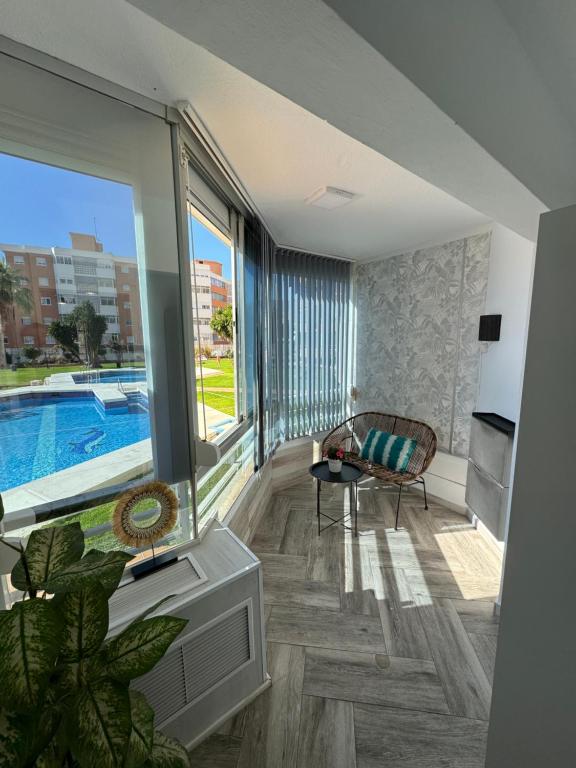 - un salon avec une grande fenêtre et une piscine dans l'établissement SaltilloLoft, à Torremolinos