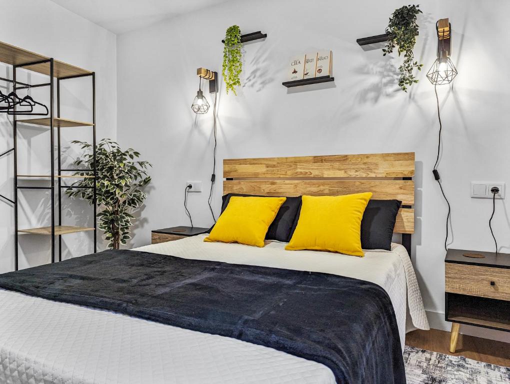 1 dormitorio con 1 cama grande con almohadas amarillas en Pedra Nova - Céntrico, Lujoso en Pontevedra