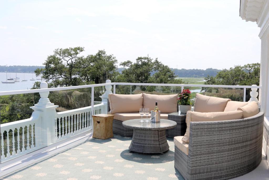 a patio with chairs and a table on a balcony at Anchorage 1770 in Beaufort