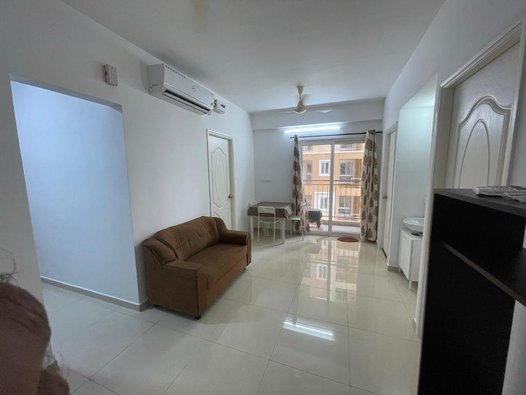 a living room with a couch and a table at Sri Sai 3 BHK Home in Kelambākkam