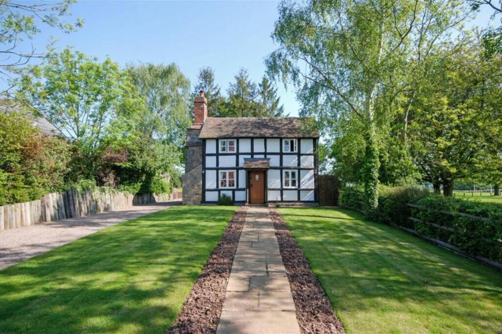 uma grande casa branca com um jardim relvado em Log Burner and Beamed Ceilings-2 Bed Cottage Crumpelbury and Whitbourne Hall less than a 4 minute drive Dog walking trails and local pub within walking distance and a 30 minute drive to the Malvern Hills em Worcester