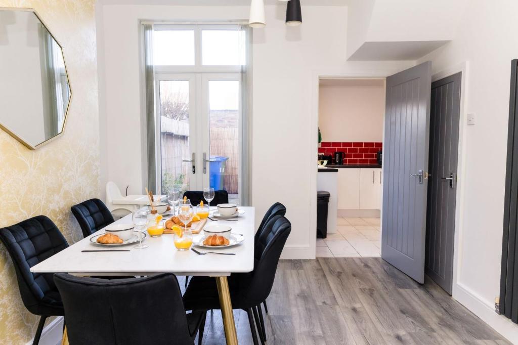 comedor con mesa blanca y sillas negras en Muriel Retreat - Central Location - Free Parking, Fast Wifi, SmartTV with Netflix by Yoko Property, en Redcar