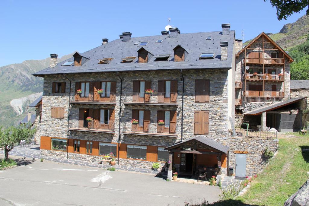 ein großes Steingebäude mit Fenstern und Balkonen in der Unterkunft Hotel Rantiner in Taull