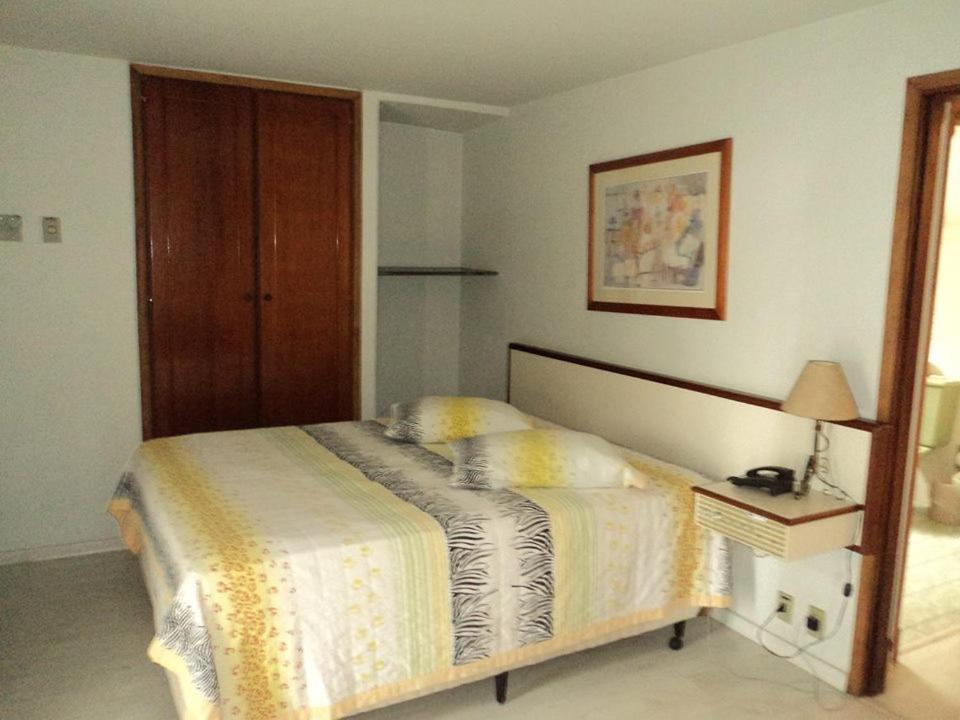 a bedroom with a bed and a table with a lamp at MAGA PLAZA HOTEL in São José do Rio Pardo