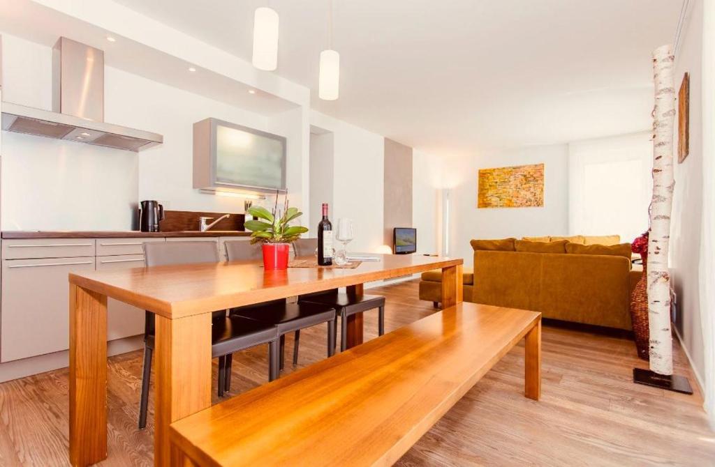 a kitchen and living room with a table and a couch at Gletscherblick Resort Kaprun by Jara in Kaprun