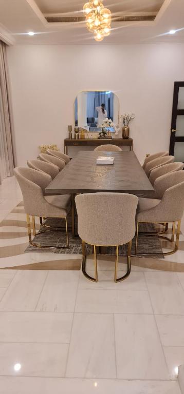 een eetkamer met een tafel en stoelen en een spiegel bij Breeze 2 in Dubai