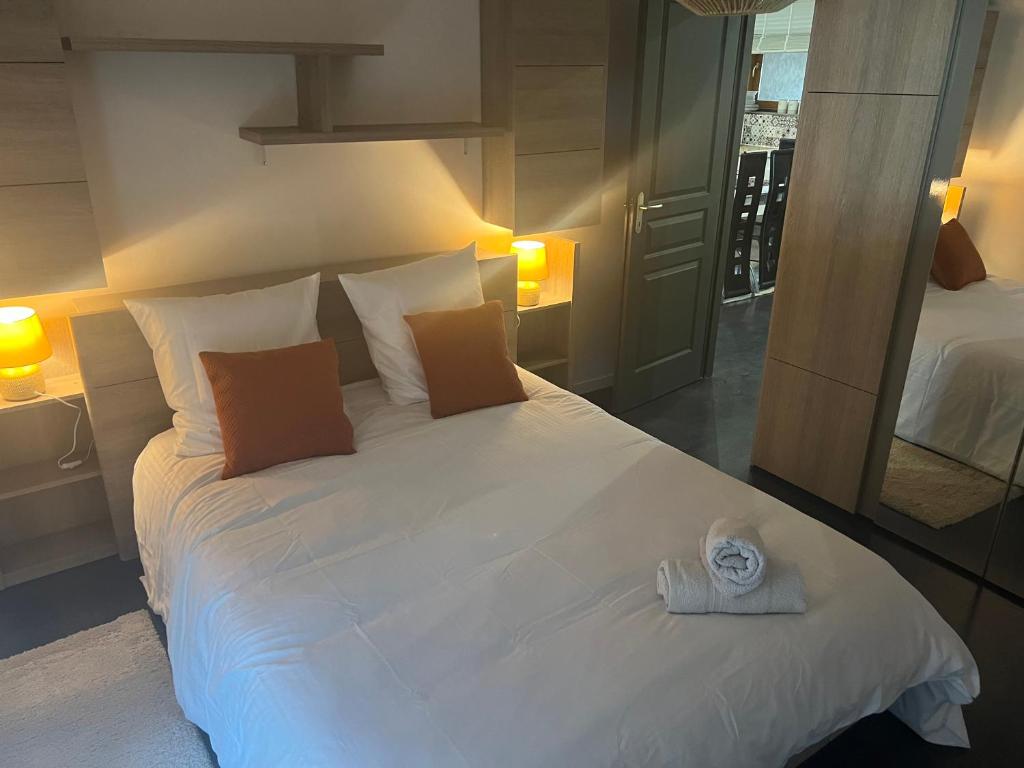 Un dormitorio con una cama blanca con una toalla. en La mansarde de la Lône, en La Roche-de-Glun