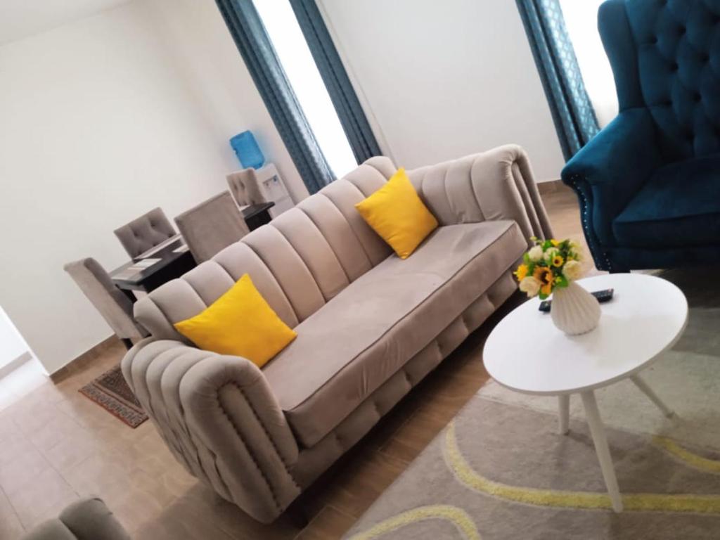 a couch with yellow pillows in a living room at Sana's crib in Kitengela 