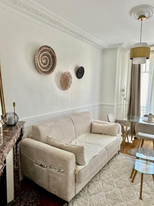 a living room with a couch and a glass table at Appartement refait à neuf au pied de paris Paris in Saint-Ouen