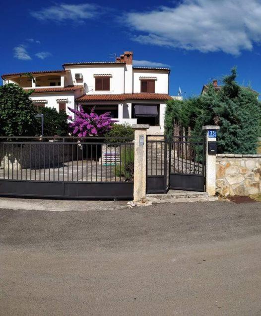 a white house with a gate in front of it at Apartmani Tara Medulin in Medulin