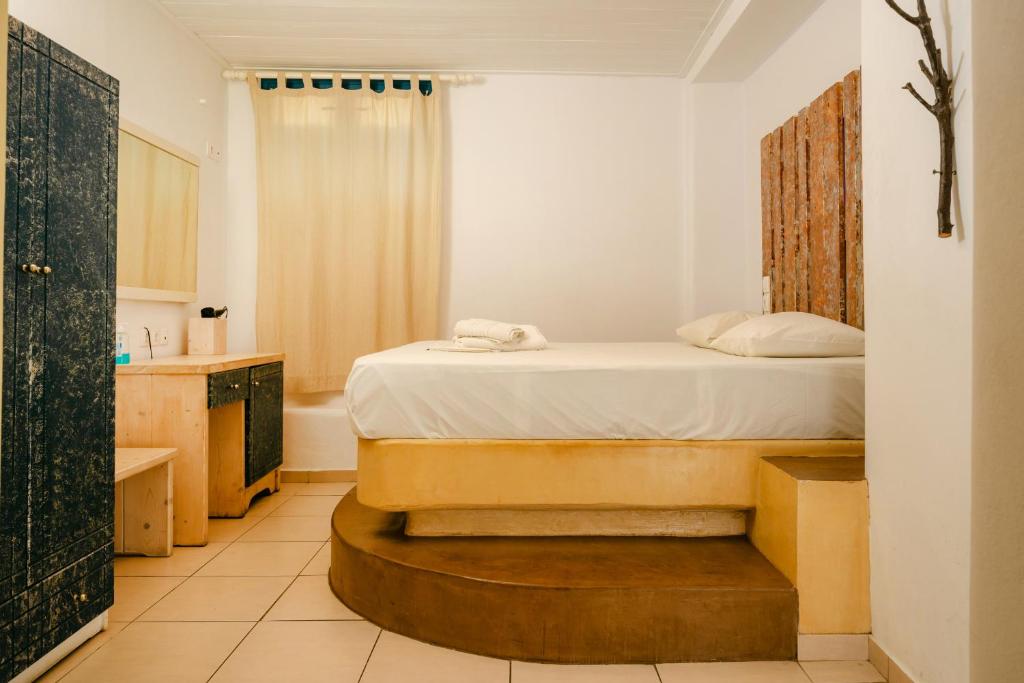 a bedroom with a bed and a bathroom with a tub at Fanari Art in Ios Chora