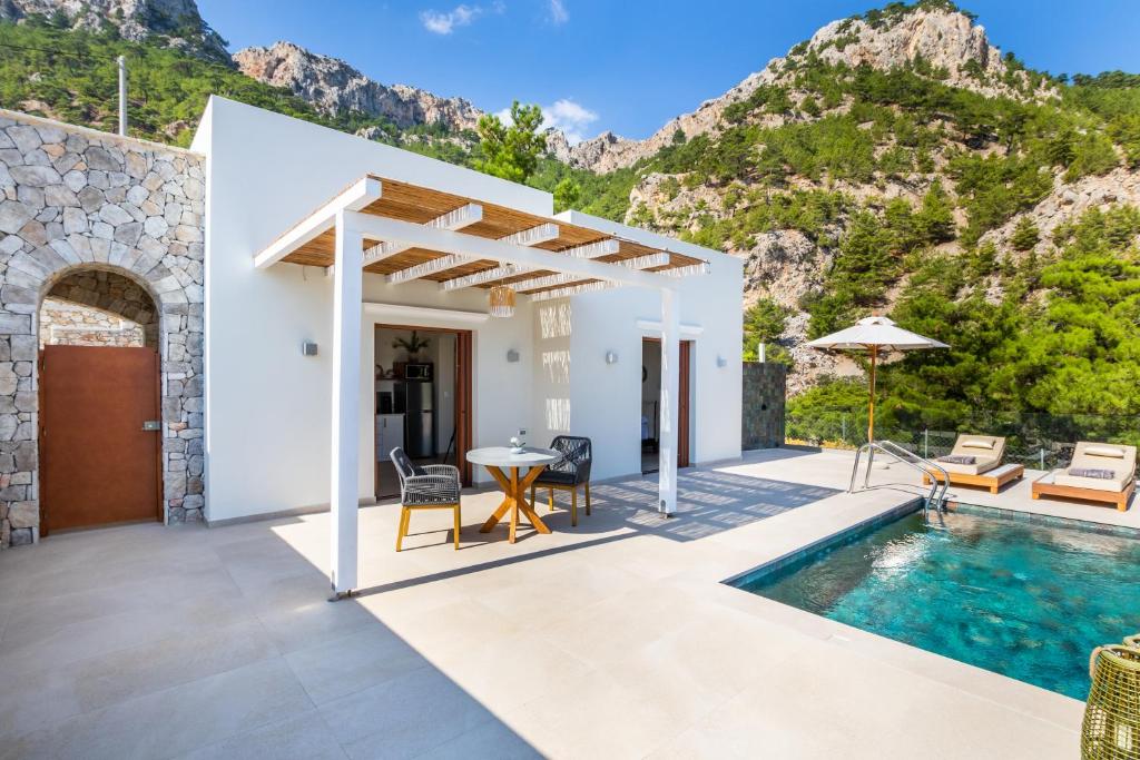 a villa with a swimming pool and a patio at MerTelia Luxury Villas in Kyra Panagia