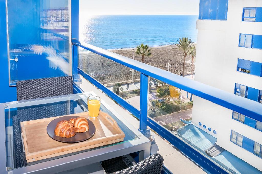 a plate of pastries on a table on a balcony with the ocean at BHost - Pacífico in Málaga