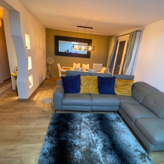 sala de estar con sofá azul y mesa en Appartement cosy Noisy le sec, en Noisy-le-Sec