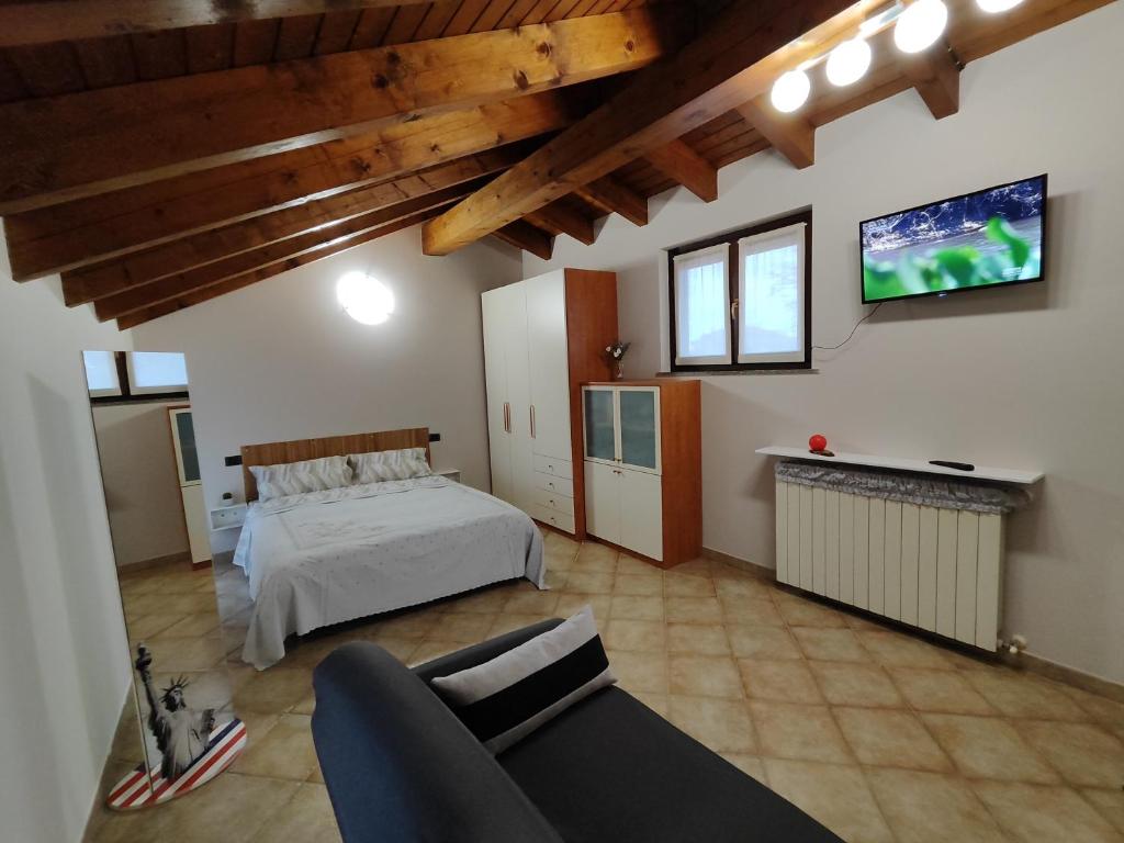 a bedroom with a bed and a tv on the wall at Casa Ninetta in Borgomanero