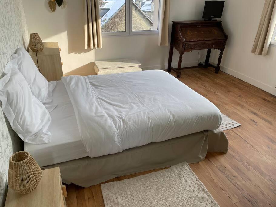 1 dormitorio con 1 cama blanca grande y piano en La Maison du Bonheur, en Sainte-Mère-Église